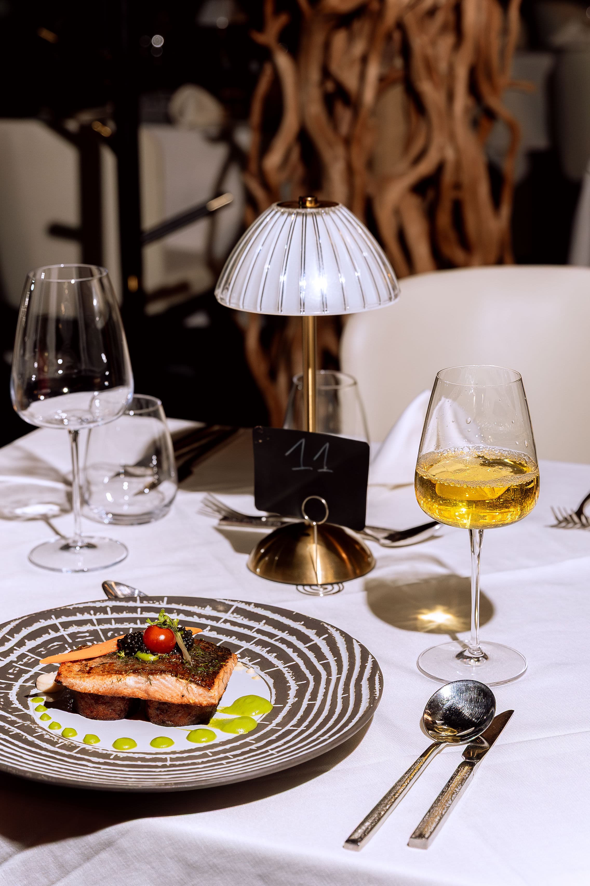 Elegant table setting with plated dish, wine glasses and ambient lighting at Le Youkounkoun