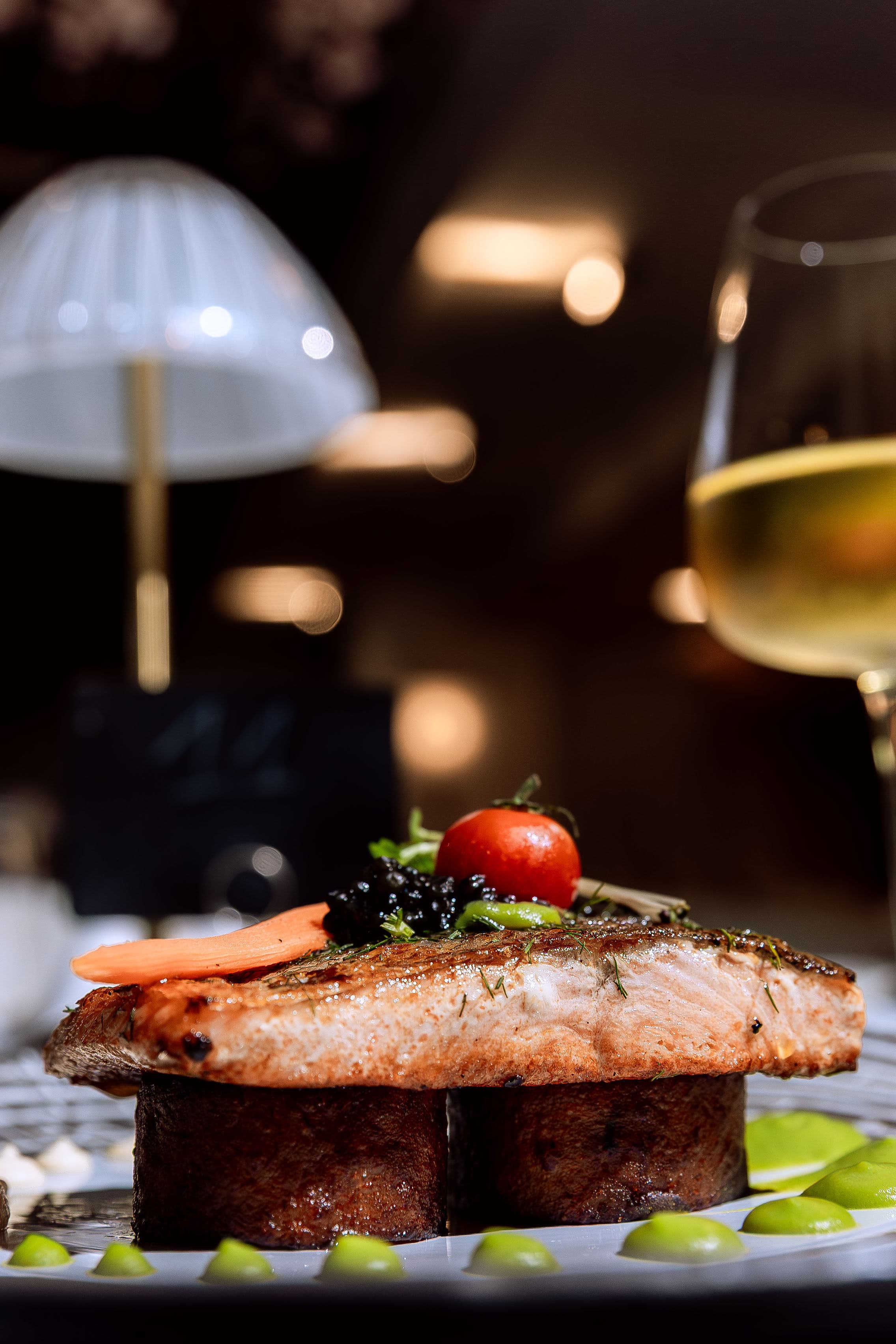 Seared fish fillet with caviar and cherry tomato, paired with white wine at Le Youkounkoun